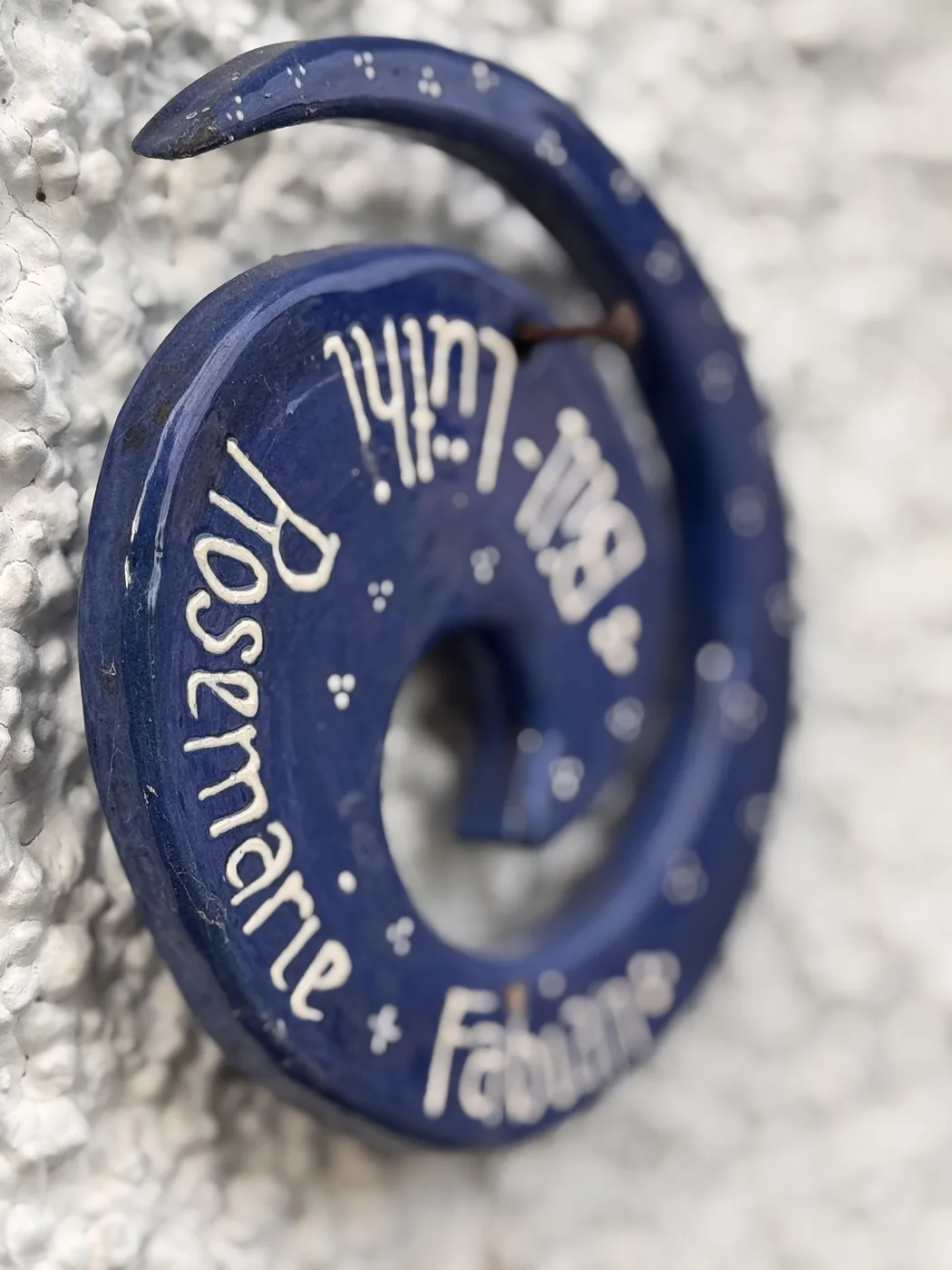 Blaues Namensschild als Spirale mit weisser Schrift